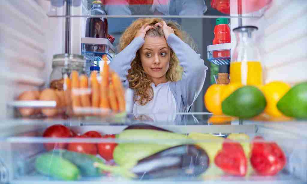 Check Refrigerator before buying foods a woman looking at her head in a refrigerator