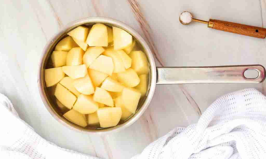 Boil the potatoes Boil the potatoes, a pot of food with a spoon and a towel