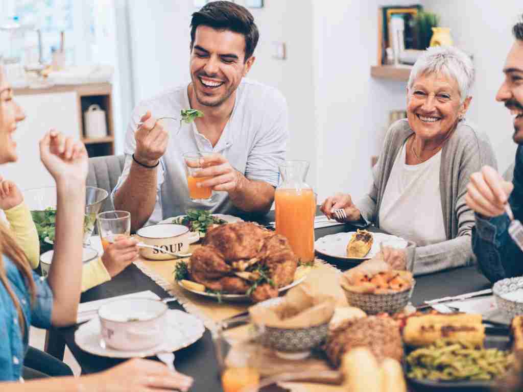 Family eating a meal at the table a group of people sitting at a table eating food
