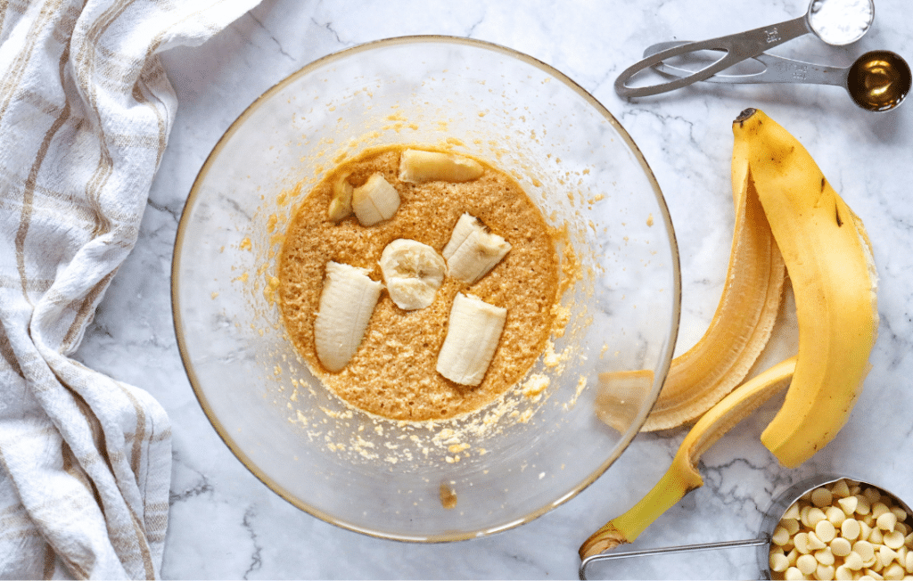 Add Wet ingredients to cookie mix a bowl with cut up bananas in it