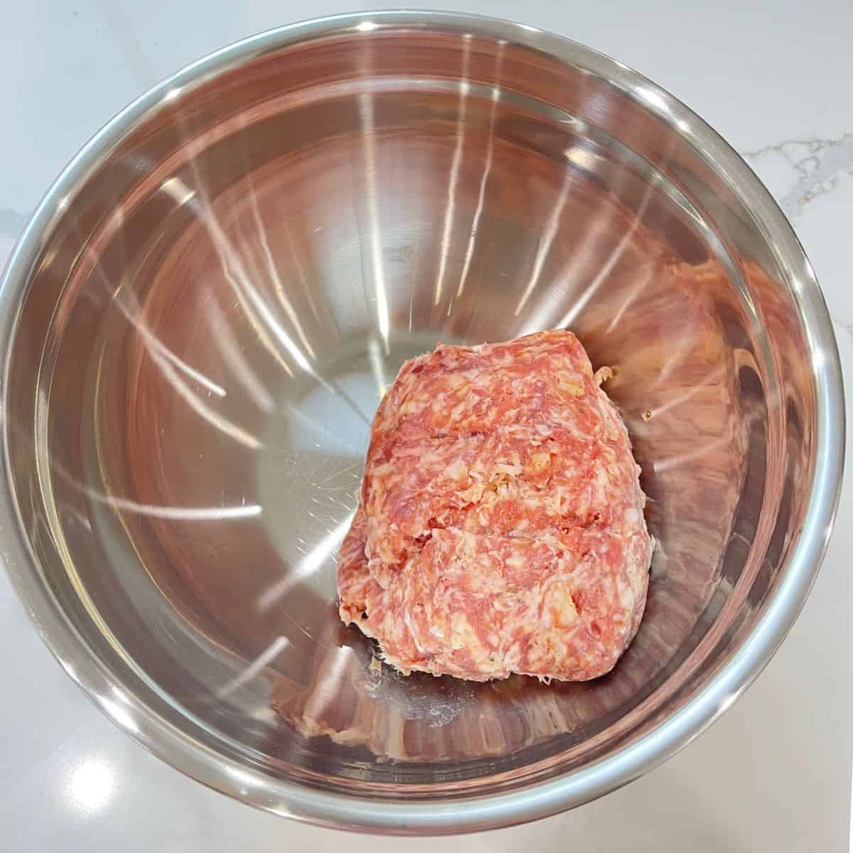 Fresh sausage in a large silver bowl