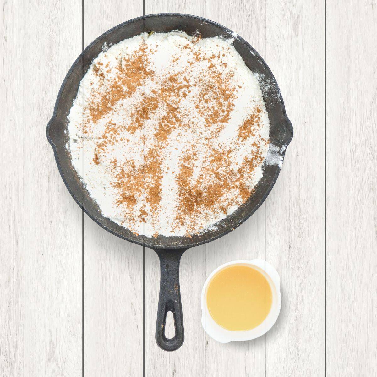 Cinnamon and cake mix in a black skillet