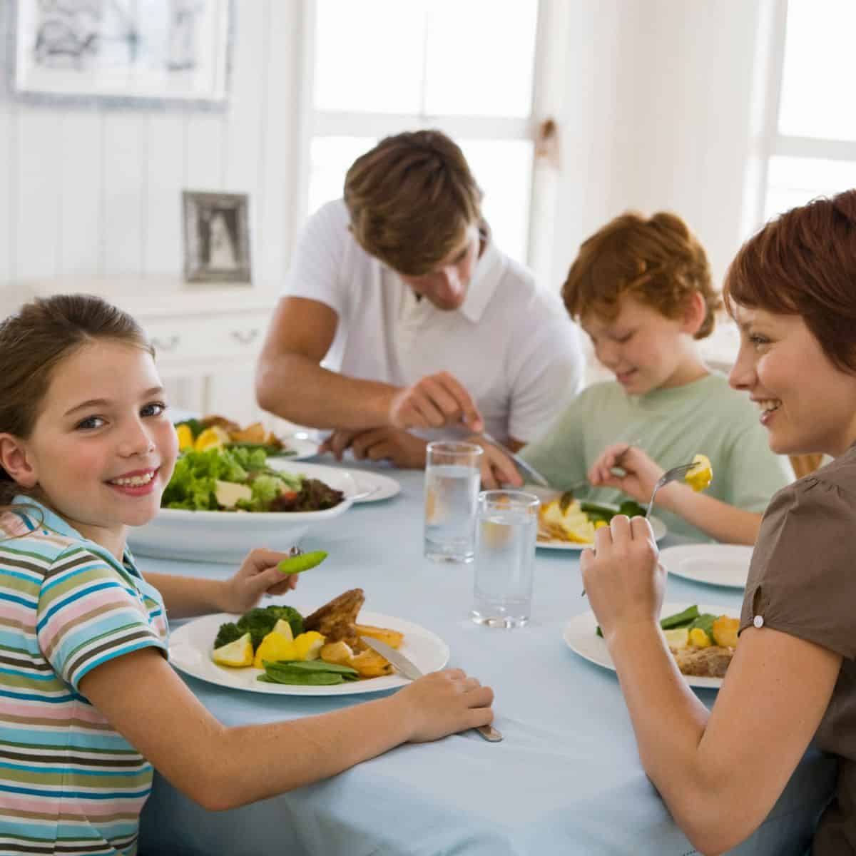 A family eating dinner together A family eating dinner at a white table