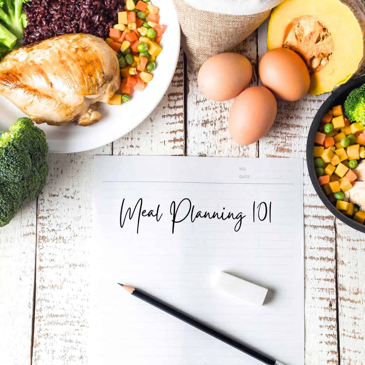 a paper that says Meal Planning 101 with a pencil and erase and vegetables on a table